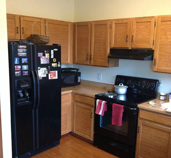Kitchen cabinets before painting, in a dated wood finish