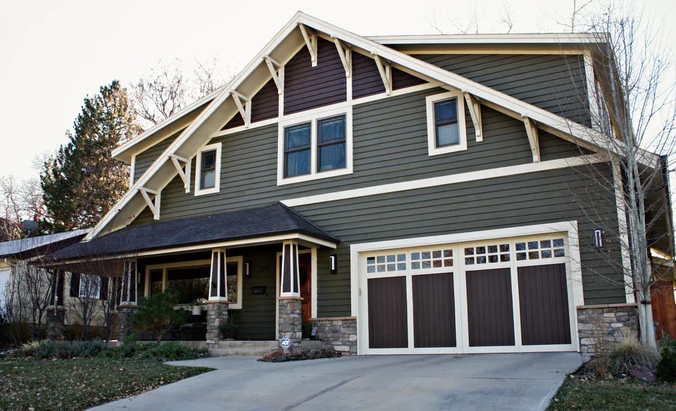 Craftsman home in Denver painted olive green with cream trim and brown garage doors